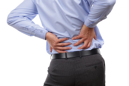 Backache concept bending over in pain with hands holding lower back